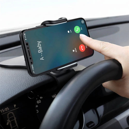 Phone mounted on a car dashboard with a hand interacting with the screen