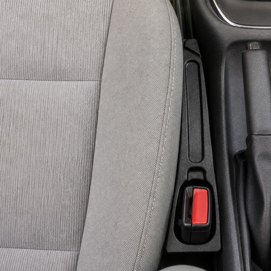 DropStop installed in the gap between the car seat and the console, seat belt buckle through the slot