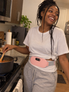 Customer wearing the pink EmberWrap™ cordless heating belt – cooking in the kitchen